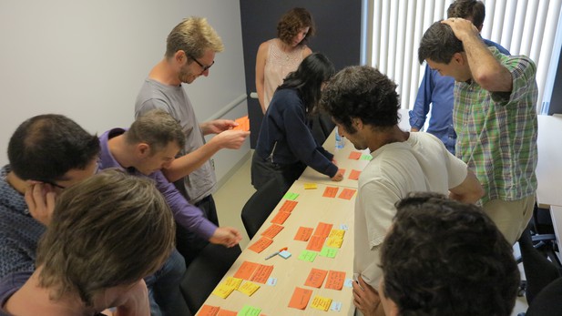 A group gather round a table covered in post-its