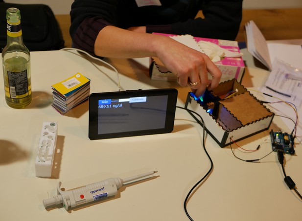 A person uses a custom-made fluorometer with the result displayed on a tablet