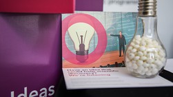 eLife postcard propped up again point of sale display saying Ideas, with lightbulb-shaped jar in foreground