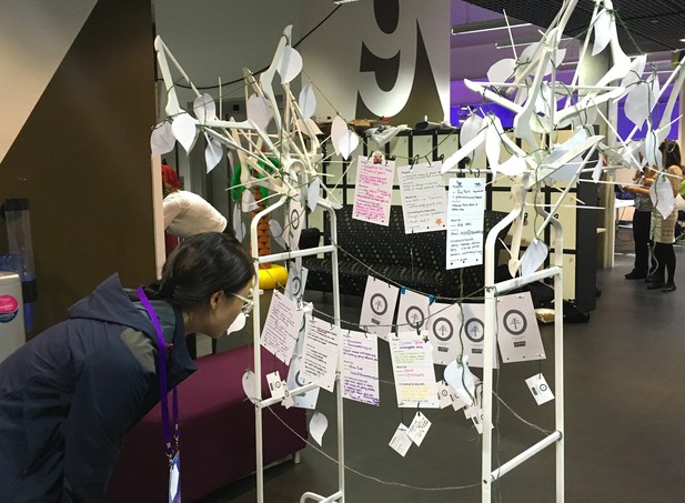 A person reads a project card on the installation