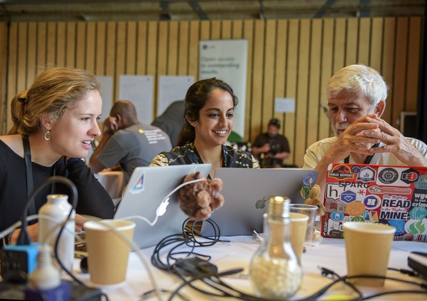 Three people working together on laptops at a table