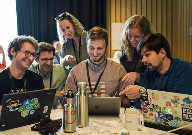 A team gather around a laptop